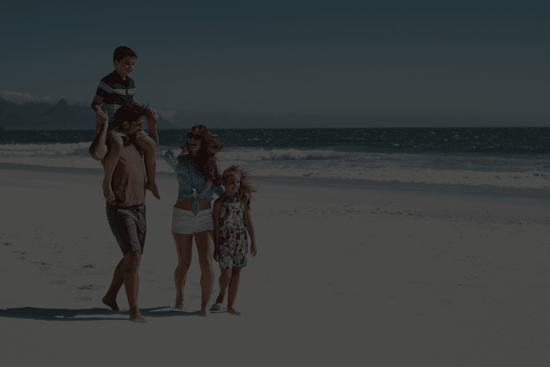 Family walking on the beach - darkened